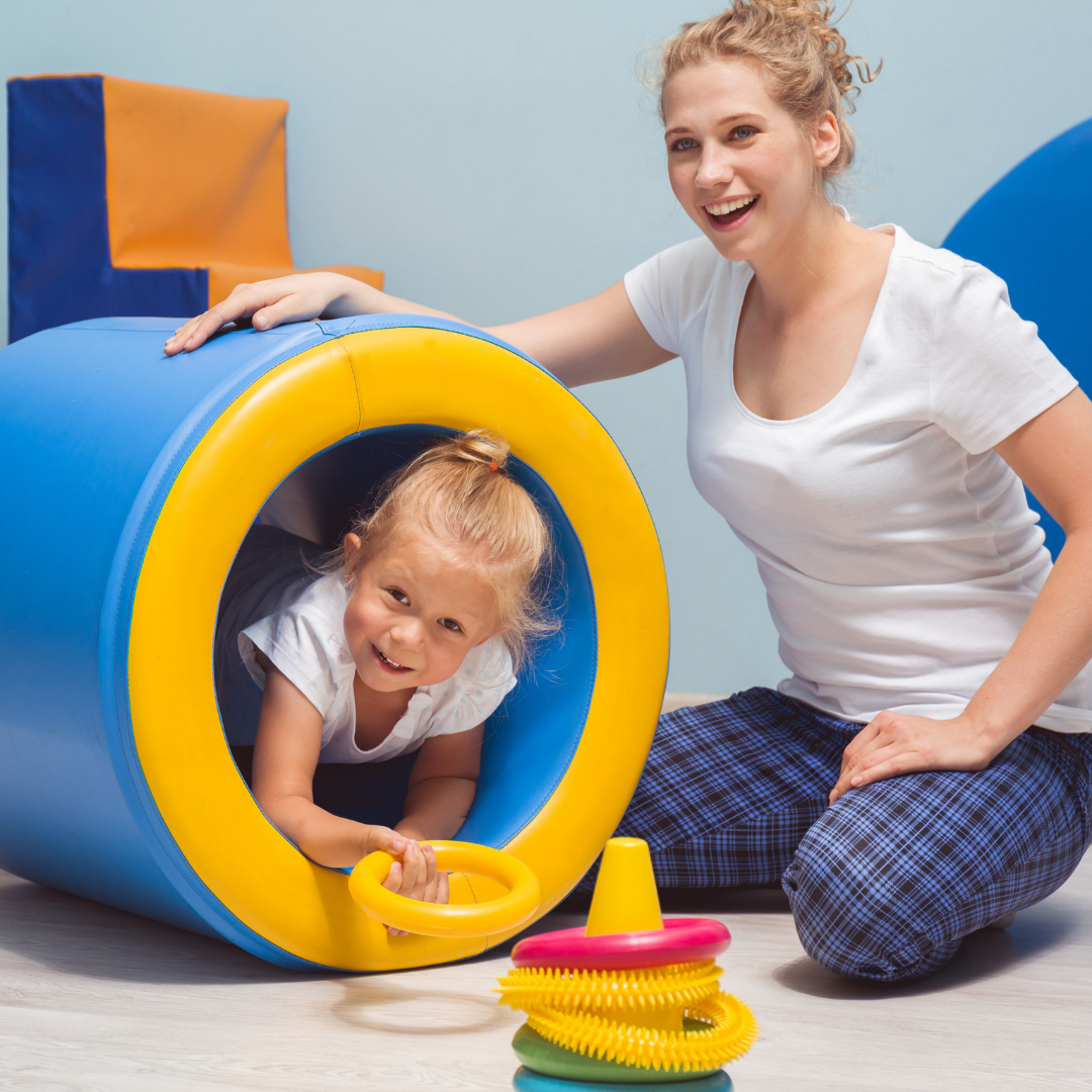 child playing in soft play area with adult supervising