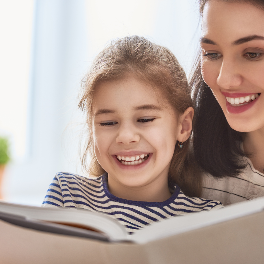 child and teacher reading a book together