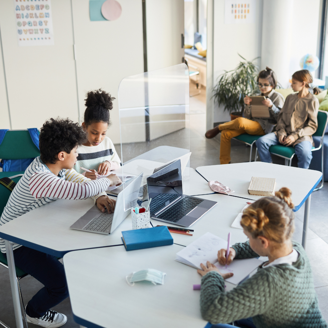 School kids in school sitting on desks