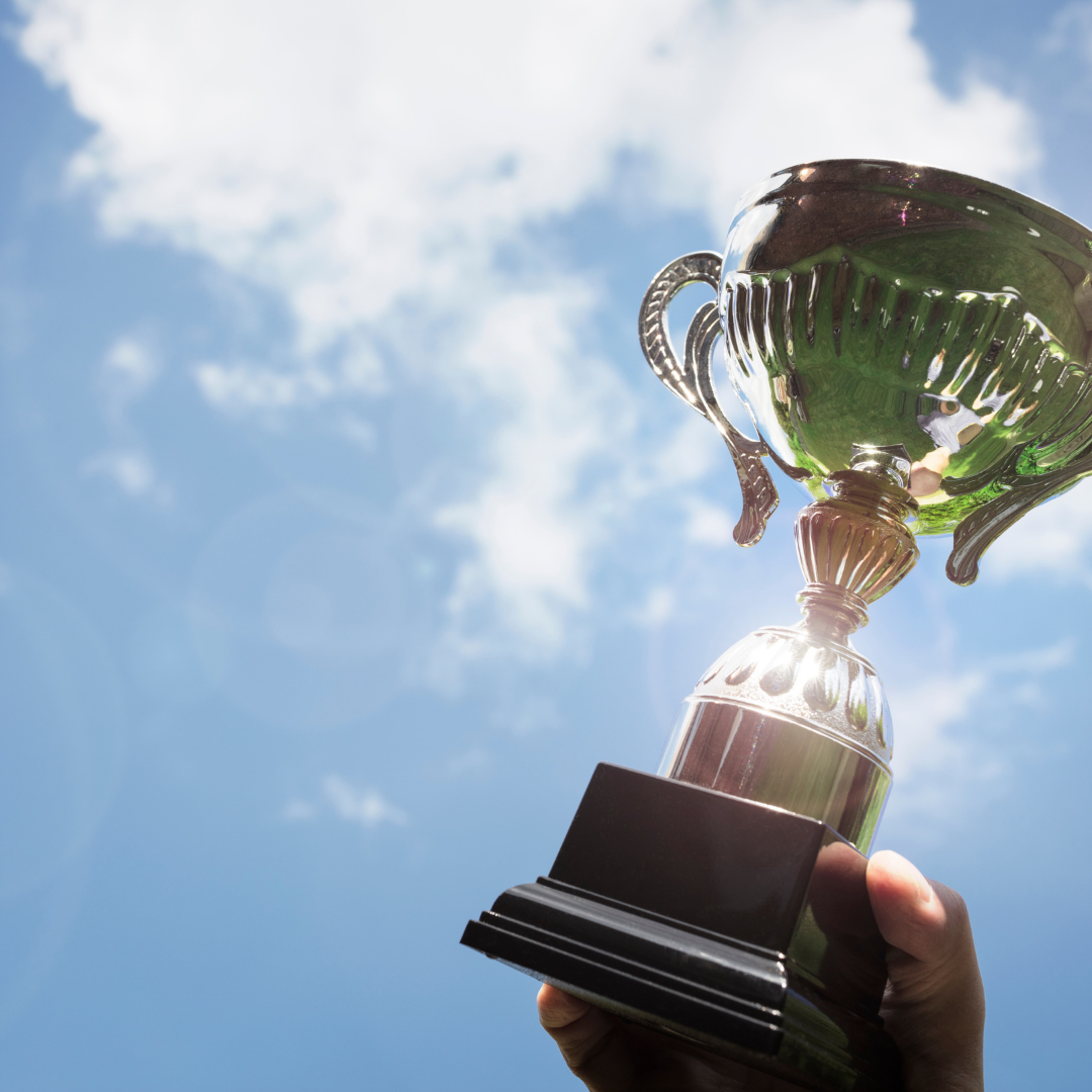 trophy being held up by the blue sky