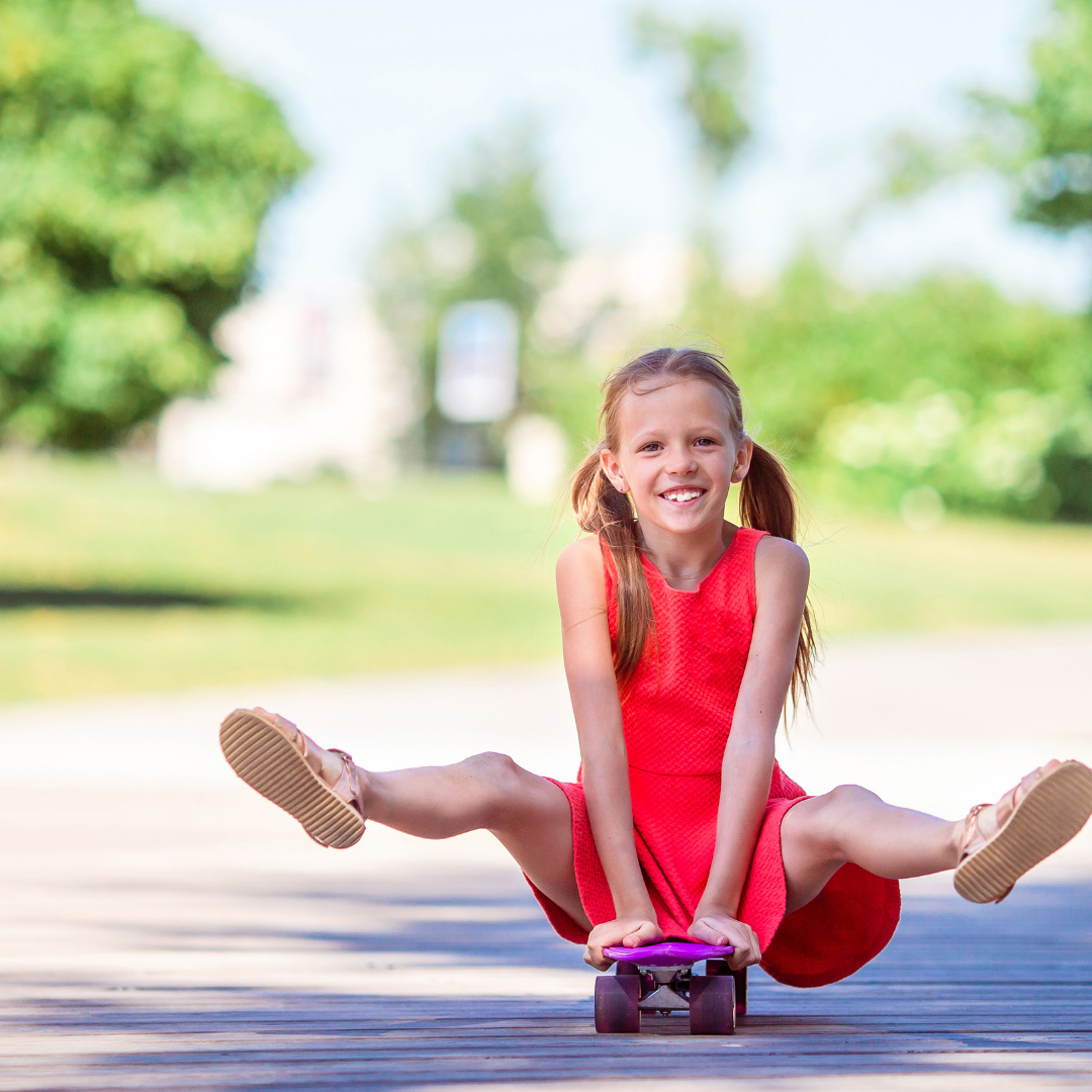 Child in red dress on skateboard