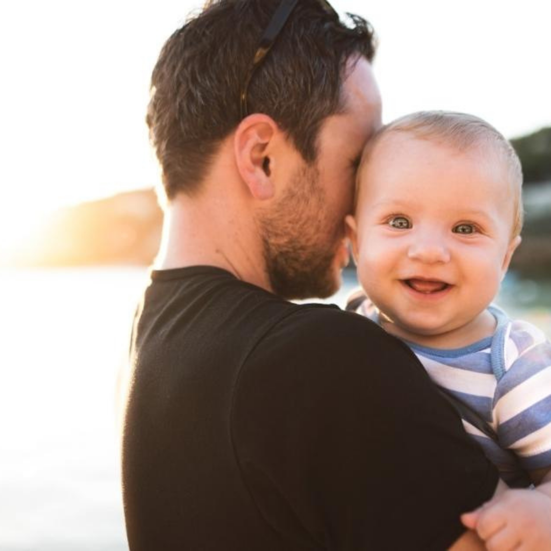 A man holding a smiling baby