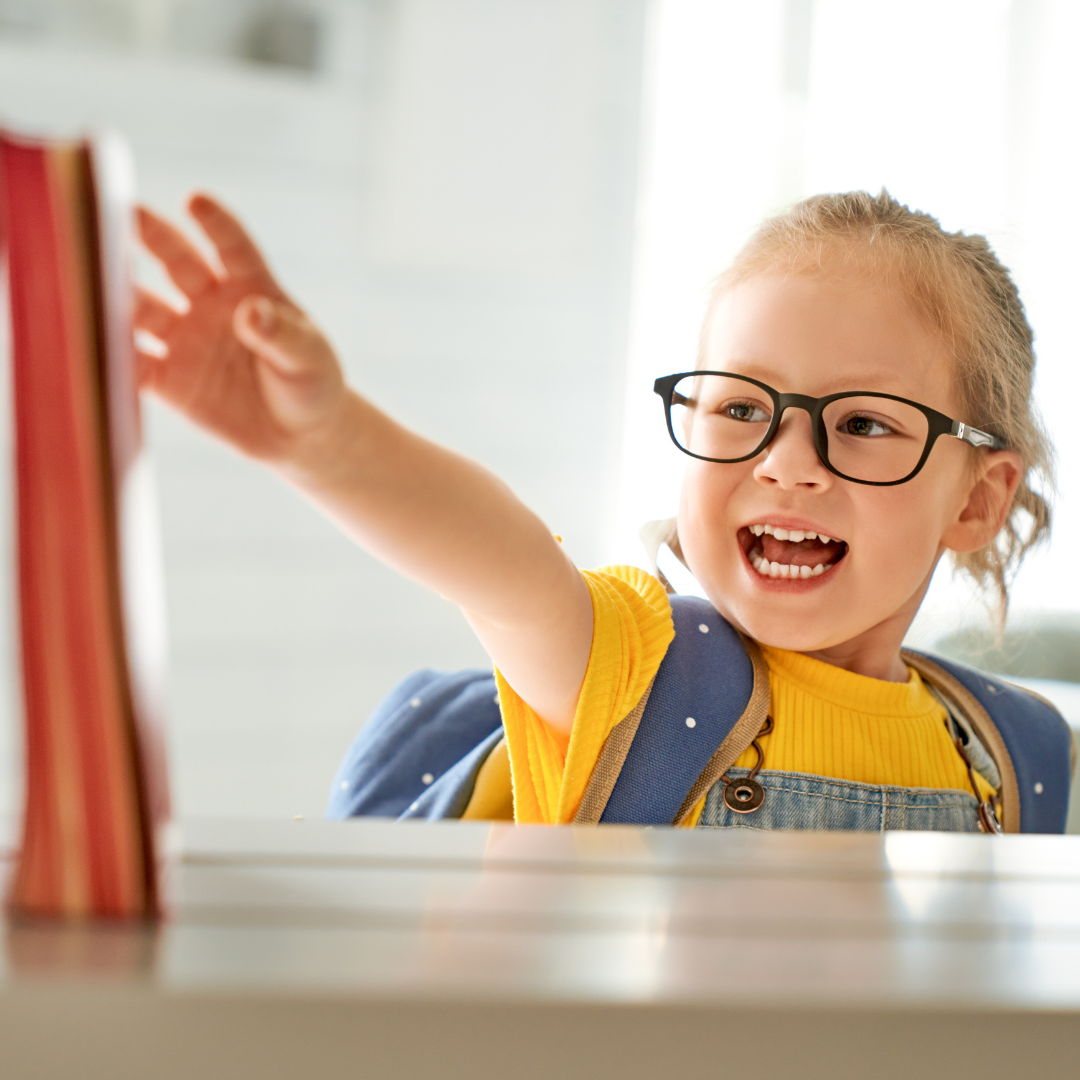 Young girl reaching out to grab books