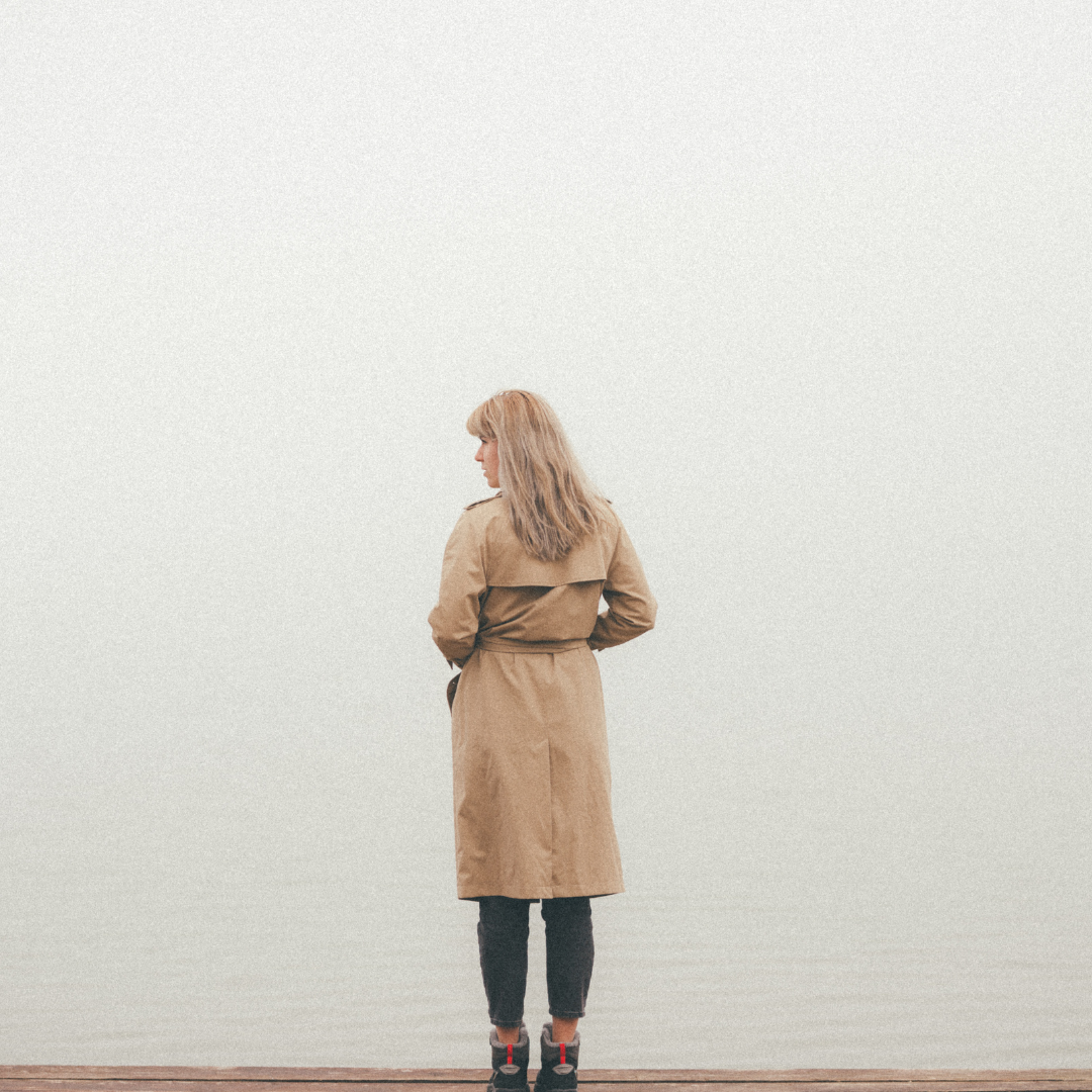 Woman in coat looking towards a wall