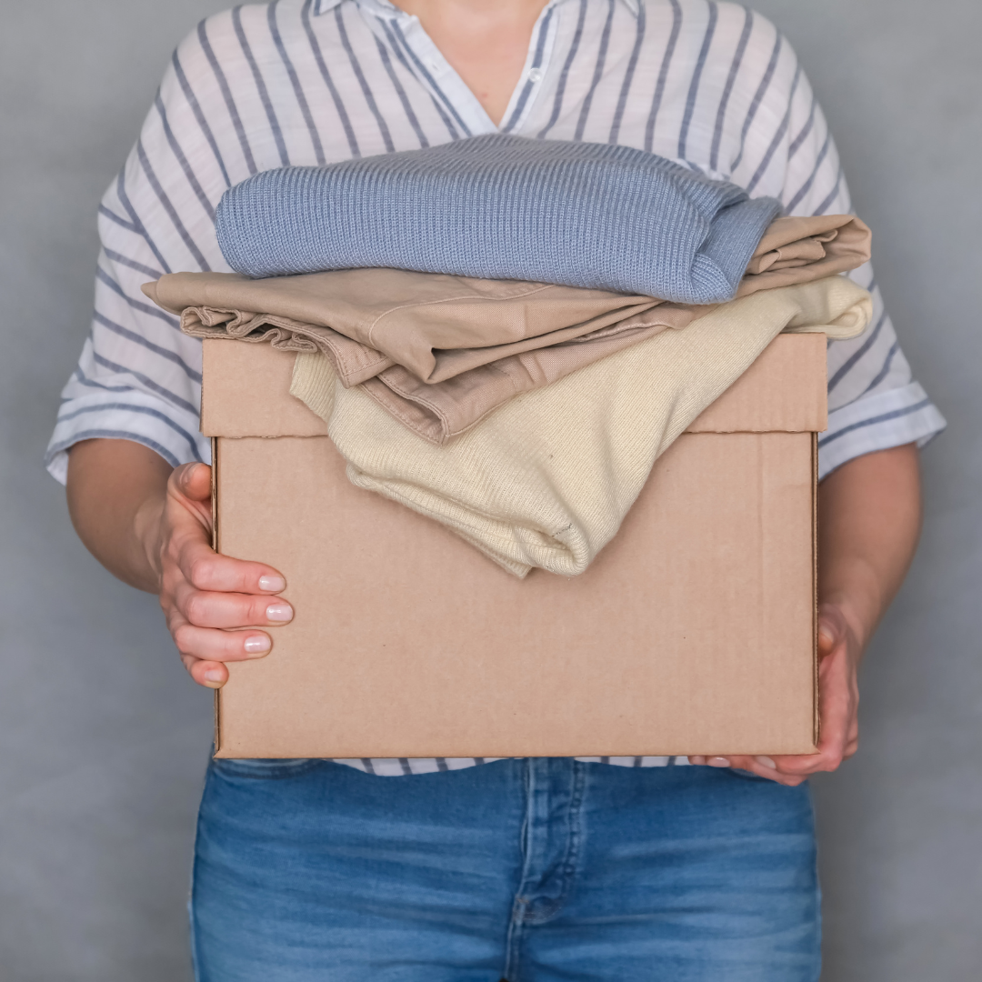 Lady carrying a box with old clothes